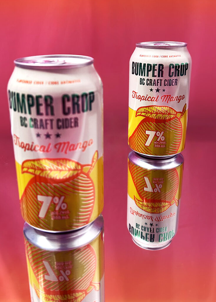 Two cider cans positioned against a bright pink backdrop.